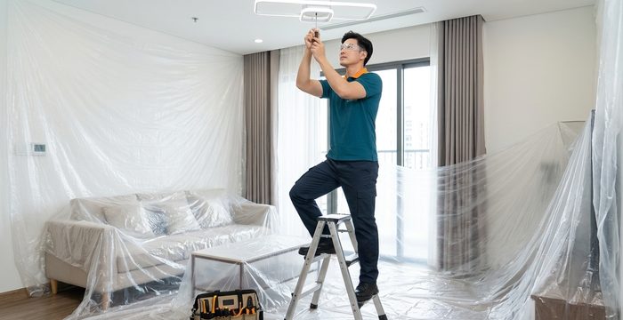 Thợ thi công sửa chữa, che chắn đồ đạc gọn gàng trong nhà khách hàng
